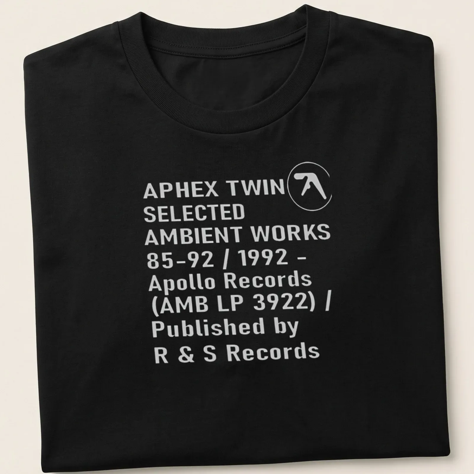 Minimalist black and white t-shirt featuring Aphex Twin album details — printed on a unisex t-shirt