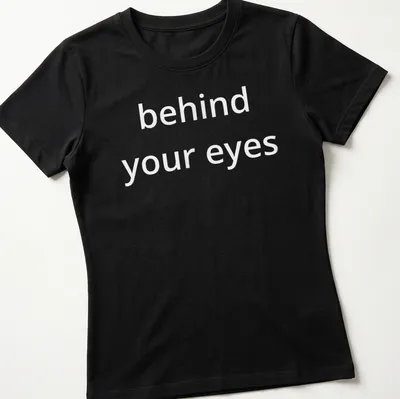 Typographic design featuring the phrase 'behind your eyes' on a minimalist T-shirt. — printed on a women's shirt