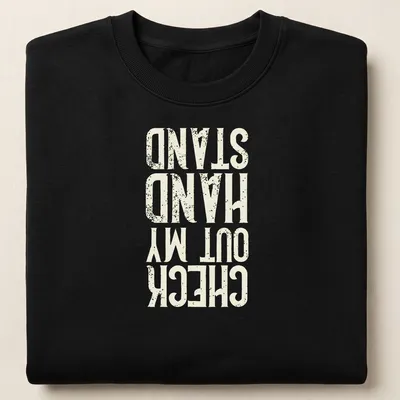 Distressed typography t-shirt featuring the phrase Check Out My Hand Stand in white, cream, and gold. — printed on a unisex sweatshirt
