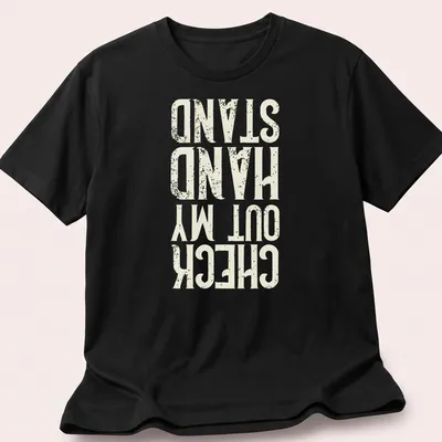 Distressed typography t-shirt featuring the phrase Check Out My Hand Stand in white, cream, and gold.