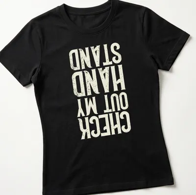 Distressed typography t-shirt featuring the phrase Check Out My Hand Stand in white, cream, and gold. — printed on a women's shirt