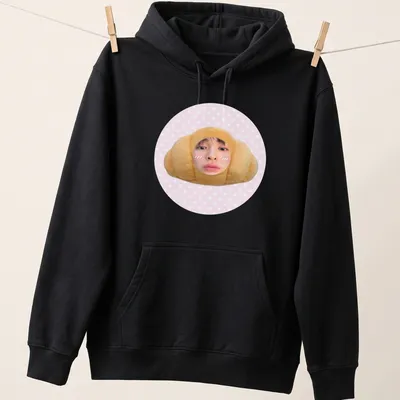 Kawaii cute croissant t-shirt featuring a smiling croissant character in pink and beige — printed on a unisex hoodie
