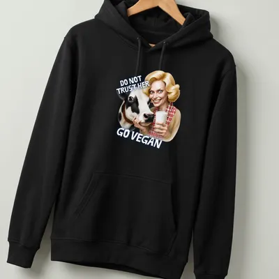 Cartoon cow graphic with bold text urging veganism in playful colors — printed on a unisex hoodie