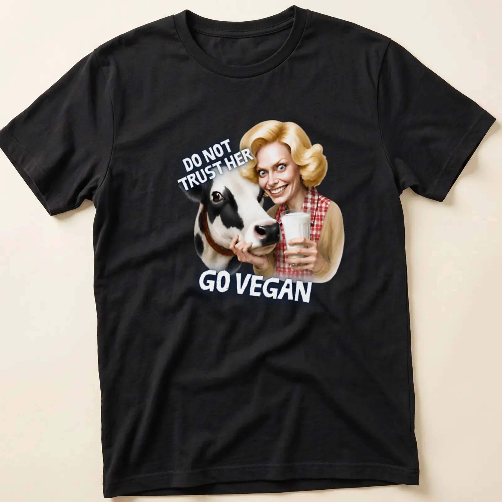 Cartoon cow graphic with bold text urging veganism in playful colors — printed on a unisex t-shirt