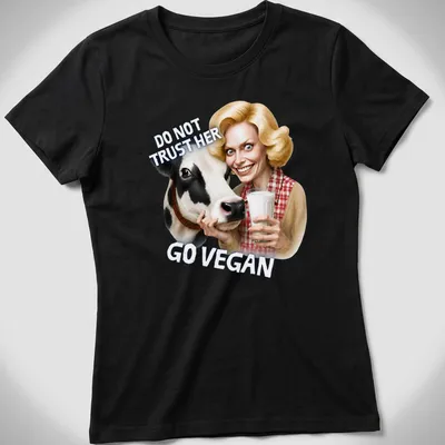 Cartoon cow graphic with bold text urging veganism in playful colors — printed on a women's shirt