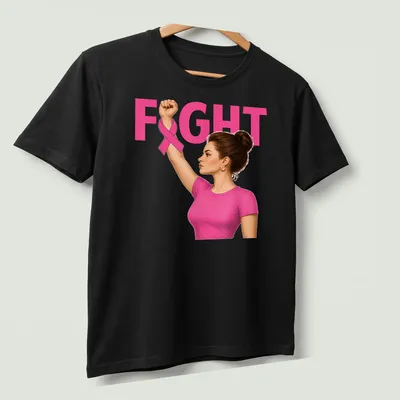 Realistic illustration of a woman raising her fist with a pink ribbon, featuring the word 'FIGHT' — printed on a unisex t-shirt (angled view)