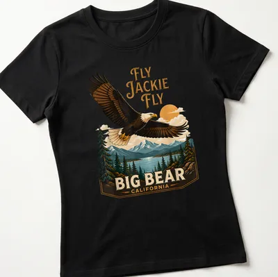 Vintage landscape tee featuring an eagle in flight with the text Fly Jackie Fly Big Bear California — printed on a women's shirt