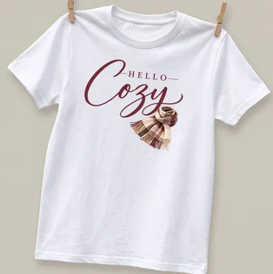 T-shirt with 'Hello Cozy' script above a plaid scarf in warm autumn colors