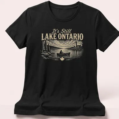 Vintage style t-shirt featuring Lake Ontario canoeing design in black, cream, and green — printed on a women's shirt