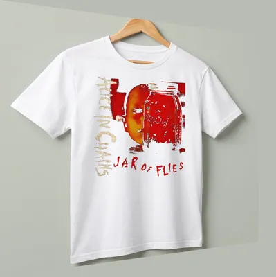 Artistic design of a jar with a face and 'Alice In Chains Jar of Flies' text in red and gold — printed on a unisex t-shirt (angled view)