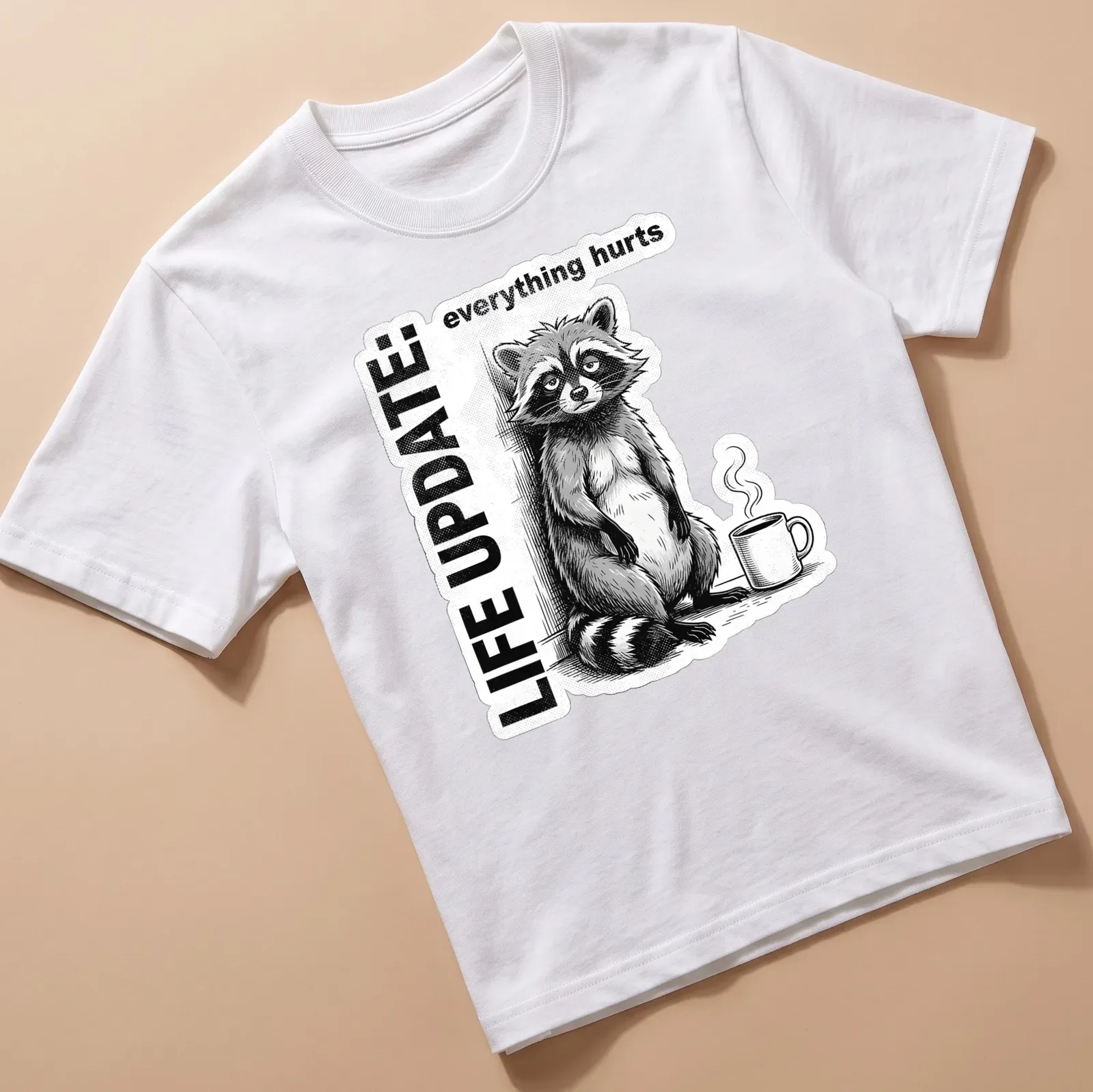 Vintage illustration of a raccoon with the text 'LIFE UPDATE: everything hurts' in black, white, and gray — printed on a unisex t-shirt