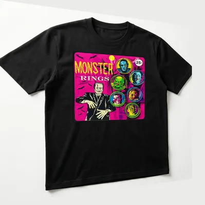 Vintage comic-style t-shirt featuring colorful monster faces and bold 'MONSTER RINGS' text — printed on a unisex t-shirt (angled view)