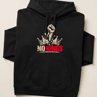 Bold graphic of a fist breaking through crowns with text 'NO KINGS' — printed on a unisex hoodie