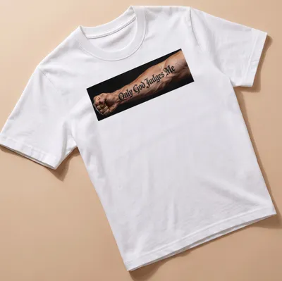 Bold script t-shirt with tattoo design reading 'Only God Judges Me' on an arm