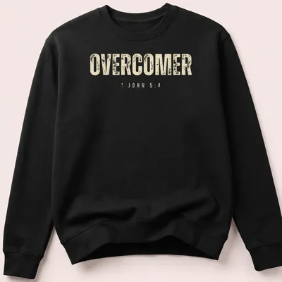 Christian faith t-shirt featuring the text 'OVERCOMER 1 JOHN 5:4' in bold, distressed lettering — printed on a unisex sweatshirt