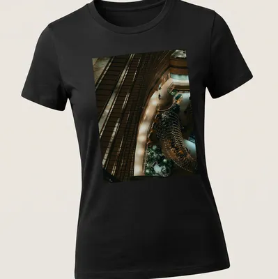Illustration of a kingfisher perched in a river scene with modern architectural style — printed on a women's shirt