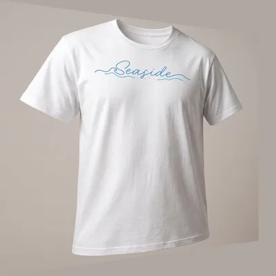 Cursive script design featuring the word Seaside over wave imagery in blue and white — printed on a unisex t-shirt (angled view)