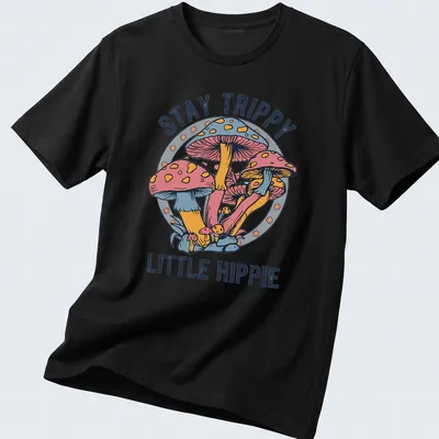 Colorful illustration of mushrooms with the text Stay Trippy Little Hippie above — printed on a unisex t-shirt
