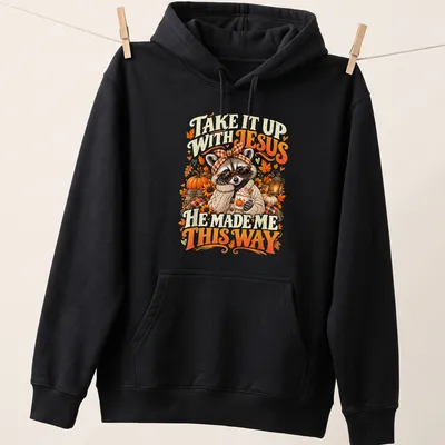 Vintage autumn-style T-shirt featuring a raccoon and playful text about Jesus. — printed on a unisex hoodie