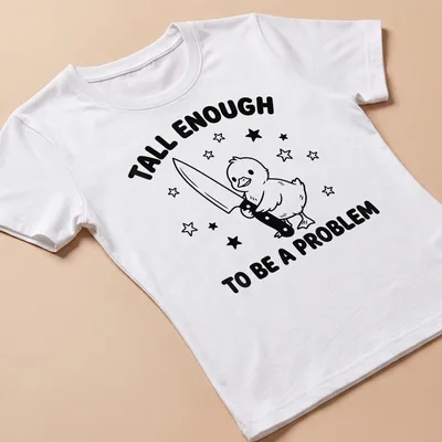 Cartoon duck holding a knife with humorous text above in black and white — printed on a women's shirt