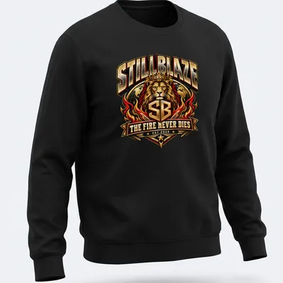 Bold typography t-shirt featuring a lion with the text 'STILLBLAZE THE FIRE NEVER DIES EST 2026' — printed on a unisex sweatshirt