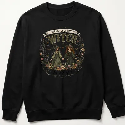 Two whimsical witches with the text 'there is a little WITCH In all of us' in vintage style — printed on a unisex sweatshirt
