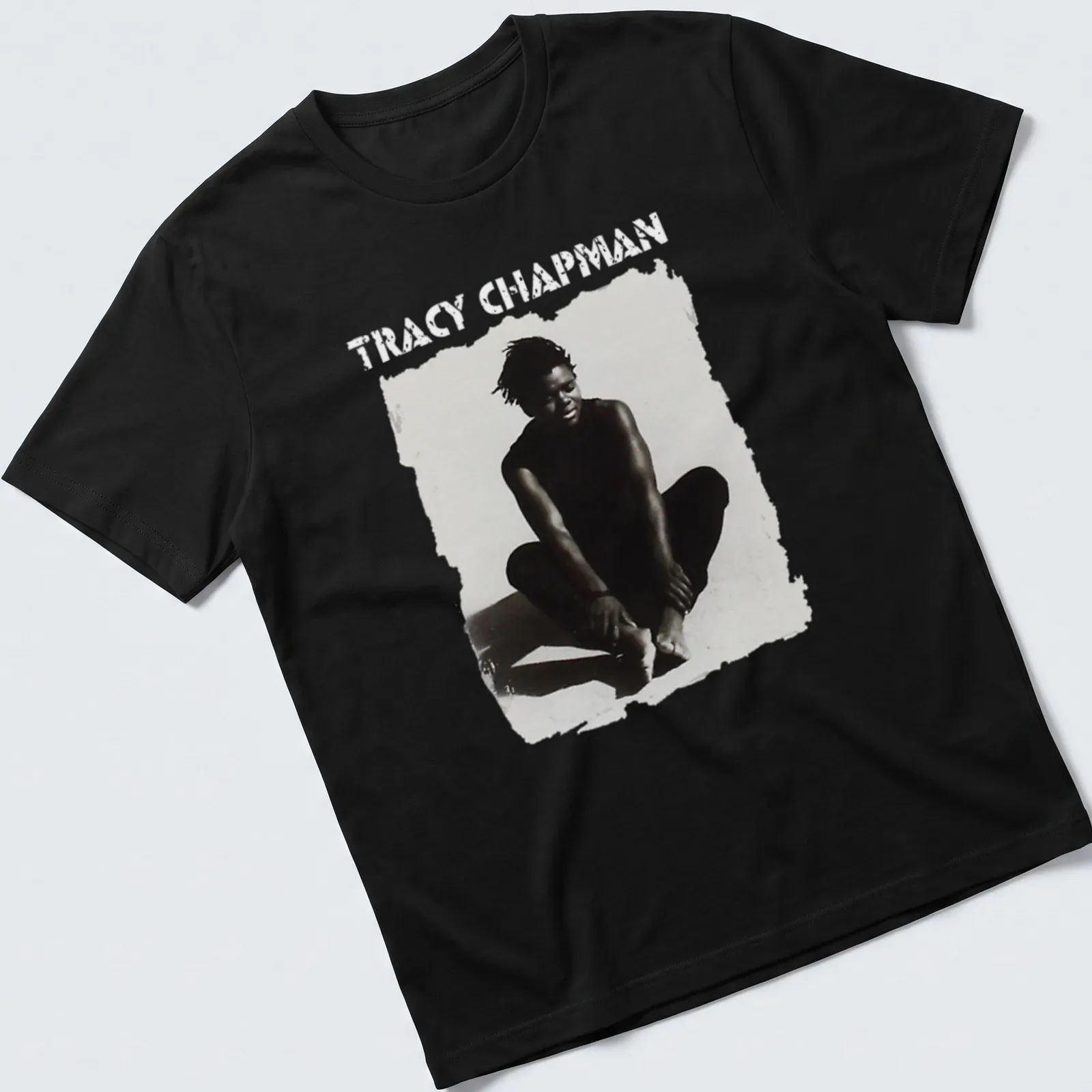 Black and white illustration of Tracy Chapman sitting with bold text below — printed on a unisex t-shirt