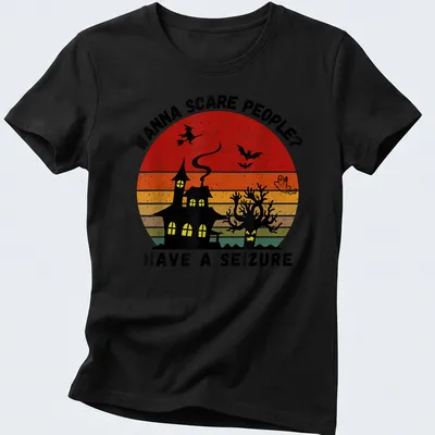 Vintage witch and haunted house graphic with bold printed text in Halloween colors — printed on a women's shirt