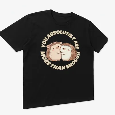 Cute hedgehogs with the text You Absolutely Are More Than Enough in a whimsical illustration. — printed on a unisex t-shirt (angled view)